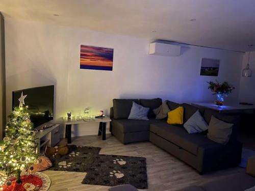 a living room with a couch and a christmas tree at Hunny Hideaway, Hunstanton - dog friendly haven by the sea in Hunstanton