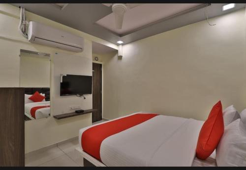 ein Hotelzimmer mit einem Bett und einem TV in der Unterkunft HOTEL SUNWAY in Ahmedabad