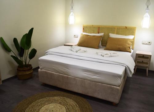 イエラペトラにあるIoanna Bayview Luxury Apartmentの大きなベッドと植物のあるベッドルーム1室が備わります。