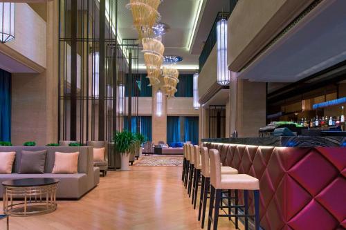 a lobby with chairs and a bar in a hotel at The Westin Qingdao - Instagrammable in Qingdao