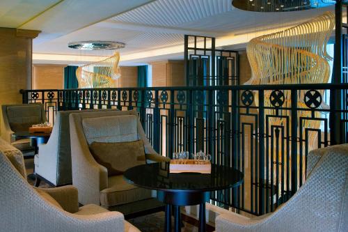 a balcony with chairs and a table in a room at The Westin Qingdao - Instagrammable in Qingdao
