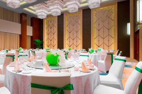 a banquet hall with white tables and white chairs at The Westin Qingdao - Instagrammable in Qingdao