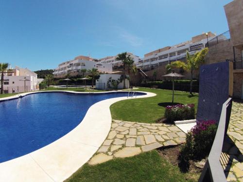 a swimming pool in the middle of a yard with buildings at 2127-Superb 2 bedrooms , lovely terraces and pool in San Roque
