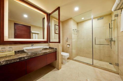 uma casa de banho com um lavatório, um chuveiro e um WC. em Four Points by Sheraton Danzhou em Danzhou