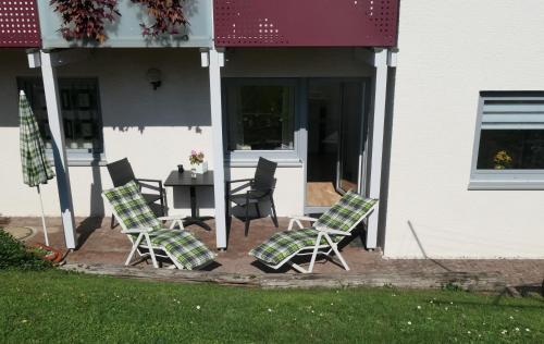 - un groupe de chaises et une table sur une terrasse couverte dans l'établissement Ferienwohnung Schneckenhaus, à Ofterdingen
