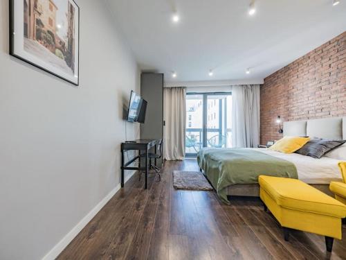 a bedroom with a bed and a brick wall at Hello Apartments Modern Industrial Browar Gdański in Gdańsk