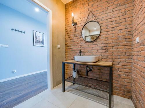 a bathroom with a sink and a brick wall at Hello Apartments Modern Industrial Browar Gdański in Gdańsk