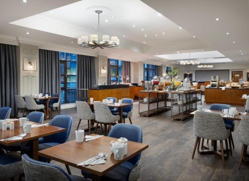 リバプールにあるDelta Hotels by Marriott Liverpool City Centreのテーブルと椅子とバーのあるレストラン