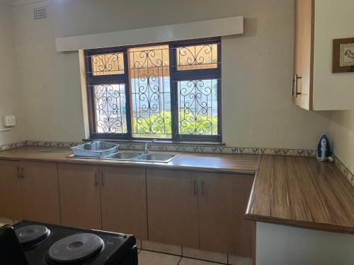 a kitchen with a sink and two stained glass windows at 10 st Johns - House in Port Shepstone