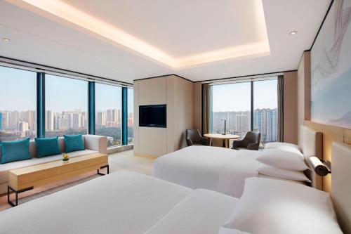 a hotel room with two beds and a tv at Four Points by Sheraton Changsha, Meixi Lake in Changsha