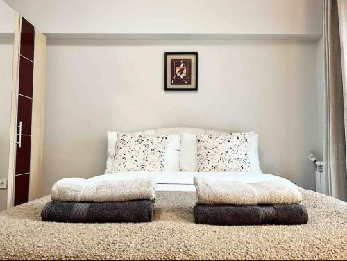 a bedroom with a bed with pillows on it at Amazing 2 bedrooms Modern Apartment in Stara Zagora in Stara Zagora