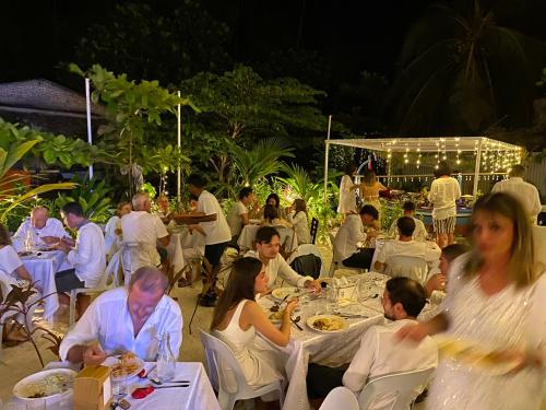 a group of people eating at a restaurant at night at VIVA Beach Maldives in Hangnaameedhoo