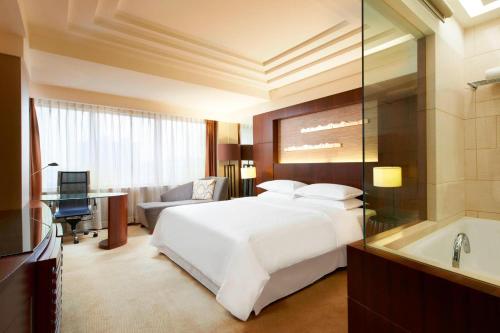 a hotel room with a bed and a bath tub at Sheraton Xiamen Hotel in Xiamen