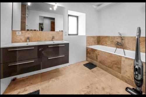 une salle de bain avec une baignoire et un lavabo et une baignoire dans l'établissement Le clos Arthur, à Pluneret