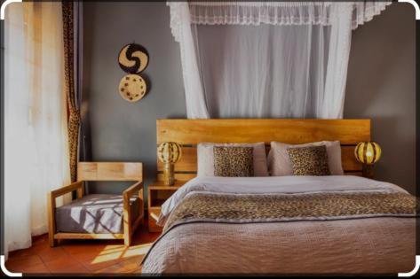 a bedroom with a bed and a clock on the wall at KIZUNGU FOREST COTTAGES & SPA in Kampala