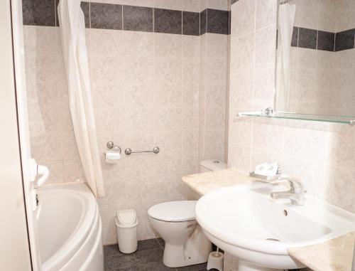 łazienka z umywalką, toaletą i wanną w obiekcie Hotel Aurora w miejscowości Sweti Konstantin i Sweta Elena