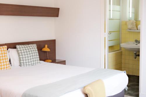 a bedroom with a large bed and a sink at Résidence Le Beau Rivage in Bandol