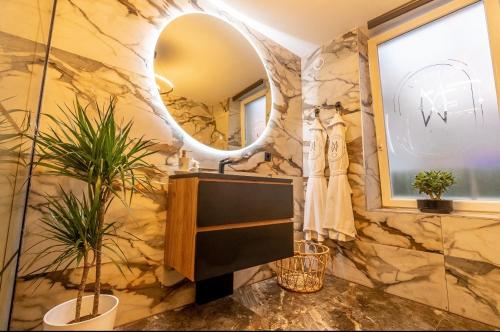 a bathroom with a stone wall and a mirror at La suite M in Verviers