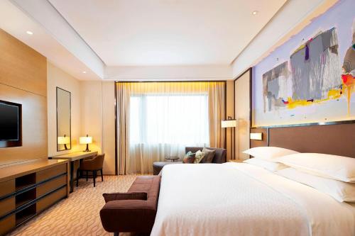 桂林Four Points By Sheraton Guilin Lingui的酒店客房设有一张大床和一台电视。