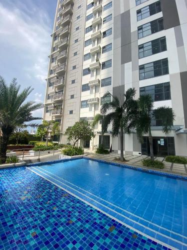 a swimming pool in front of a tall building at Horizons 101 Condominium in Cebu City