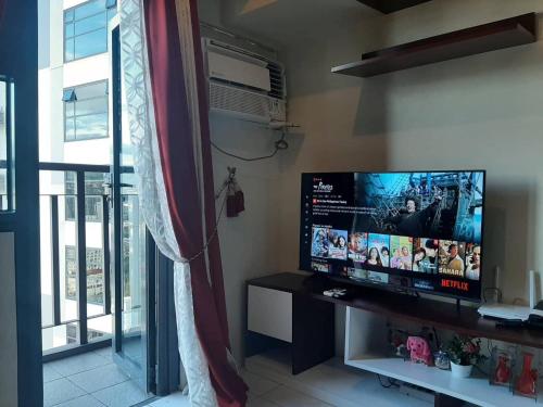 sala de estar con TV de pantalla plana y ventana en Horizons 101 Condominium, en Cebú