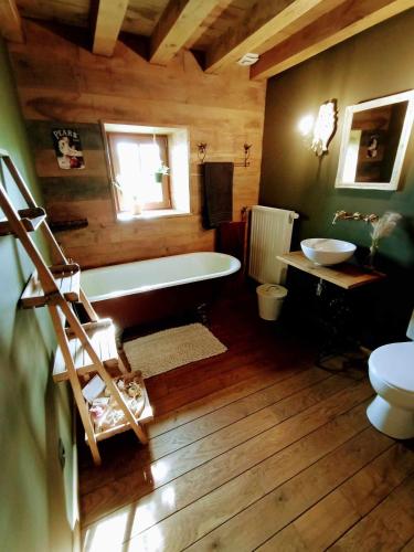 a bathroom with a tub and a toilet and a sink at La Grange in Fter