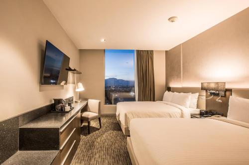 a hotel room with two beds and a window at Four Points by Sheraton Puebla in Puebla