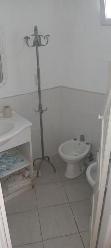 a white bathroom with a toilet and a sink at Monoambiente in Punta del Este