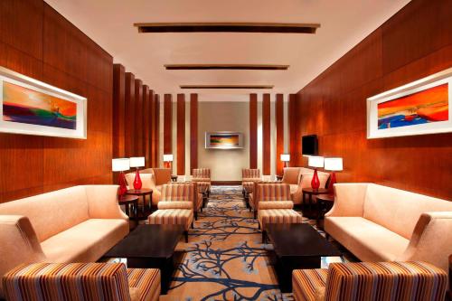 a waiting room with couches and tables and paintings at Sheraton Guangzhou Hotel in Guangzhou