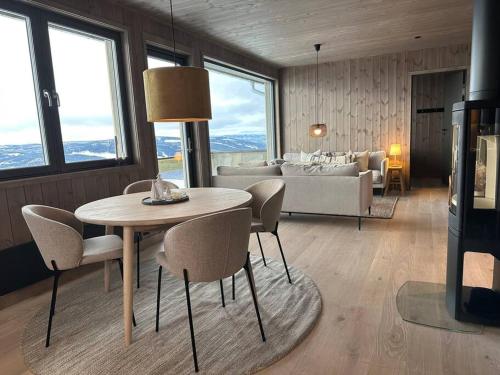 sala de estar con mesa, sillas y sofá en Hafjell - Penthouse - ski in/out, en Hafjell