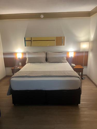 a bedroom with a large bed with two lamps at Flat VMariana PqIbirapuera Borges Lagoa com garagem 1105 in Sao Paulo