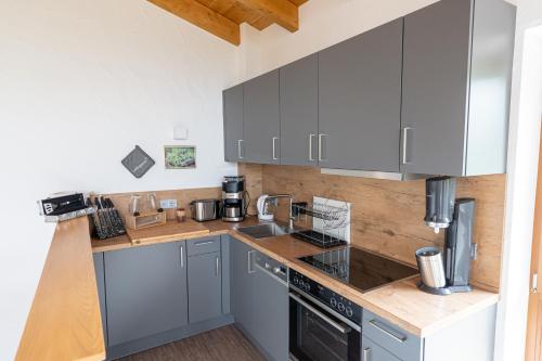 a kitchen with gray cabinets and a wooden counter top at Bergdorf Spessart in Flörsbachtal