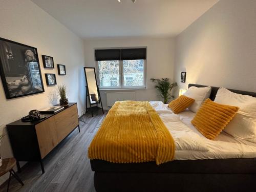 um quarto com uma cama grande com um cobertor amarelo em ThreeRoom Gem of Essen em Essen