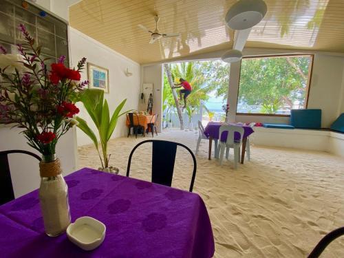 a purple table with a vase of flowers on it at VIVA Beach Maldives in Hangnaameedhoo