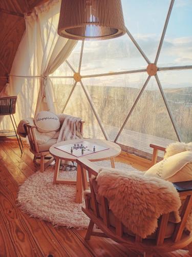 a room with a tent with a table and a window at Bóreas Ecoluxury Glamping in El Calafate