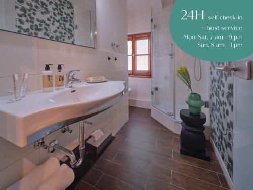 a white bathroom with a sink and a shower at Classik Hotel Martinshof München Messe in Munich