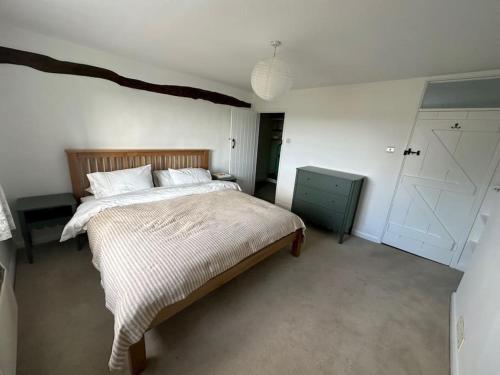 ein Schlafzimmer mit einem großen Bett und einem blauen Schrank in der Unterkunft Badgers Cottage 