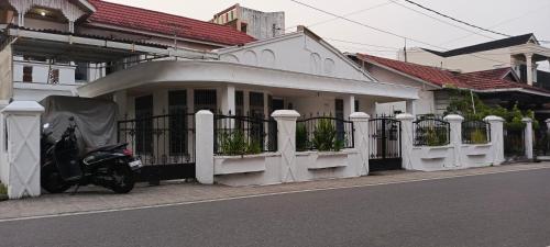 una motocicleta estacionada frente a una casa blanca en Penginapan Terdekat (Near), en Bukittinggi