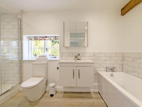 uma casa de banho com um WC, um lavatório e uma banheira em Badgers Cottage 