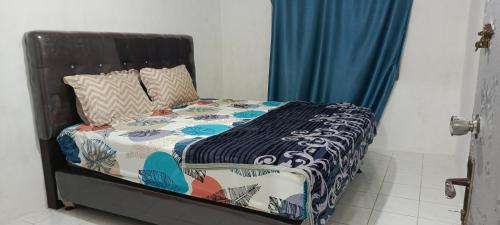 Bett mit einer Decke auf dem Zimmer in der Unterkunft Penginapan Terdekat (Near) in Bukittinggi
