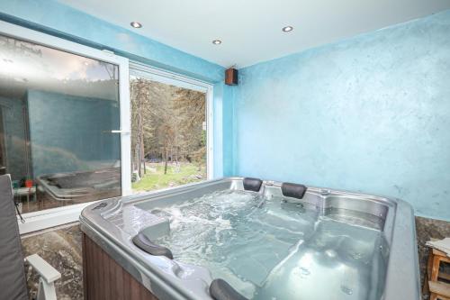 eine Badewanne im Bad mit Fenster in der Unterkunft Vila POGLED Wellness i spa in Divčibare