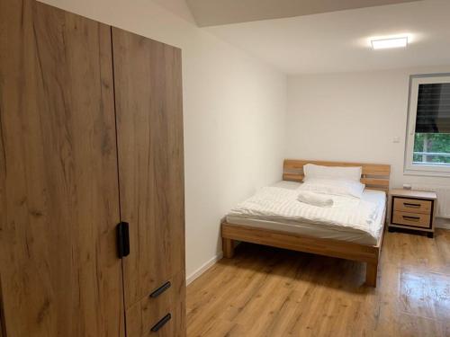 - une chambre avec un lit et une grande armoire en bois dans l'établissement Gasthaus Pinneberg, à Pinneberg