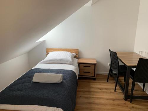 Schlafzimmer mit einem Bett, einem Schreibtisch und einem Tisch in der Unterkunft Gasthaus Pinneberg in Pinneberg