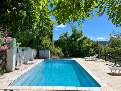 une piscine dans l'arrière-cour d'une maison dans l'établissement La Roseraie - Gite avec piscine en Cévennes, à Roquedur
