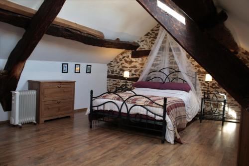 une chambre avec un lit et un mur en pierre dans l'établissement L'Oustal du Viaur - Gîtes Tournesol and Coquelicot, à Pampelonne