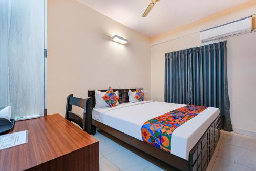 een slaapkamer met een bed en een bureau en een bed sidx sidx sidx bij FabHotel Valleyton Suites in Bangalore
