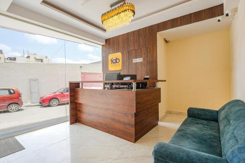 a living room with a couch and a desk at FabHotel Crystal Suites - Near Marathahalli Junction in Bengaluru