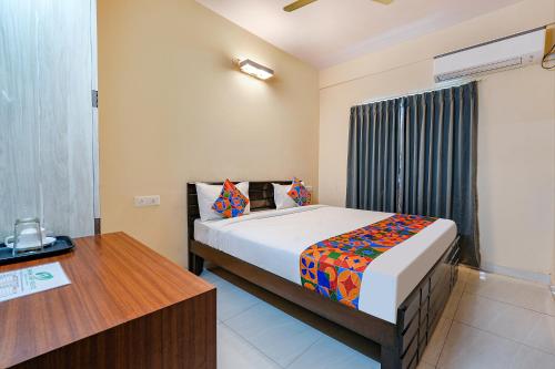 een slaapkamer met een bed en een bureau in een kamer bij FabHotel Valleyton Suites in Bangalore