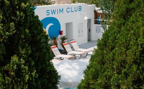 un grupo de sillas de jardín frente a un club de natación en El Rey Court, en Santa Fe