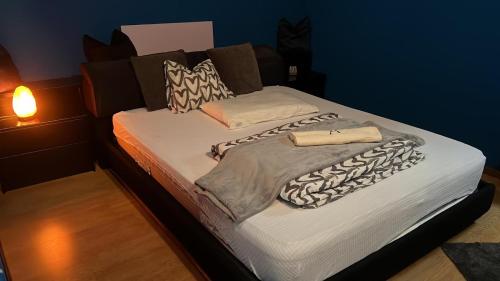 ein großes Bett mit weißer Bettwäsche und Kissen darauf in der Unterkunft Casa vacanza Noe’ -Longarone (BL) 